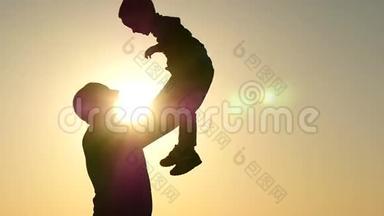 一个快乐的父亲的<strong>剪影</strong>，他把他的孩子扔上来抓住他。 幸福家庭的<strong>剪影</strong>。 幸福的概念
